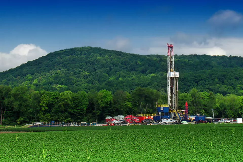 Marcellus shale gas-drilling site with tall white tower against green hills along PA Route 87, Lycoming County, Pennsylvania